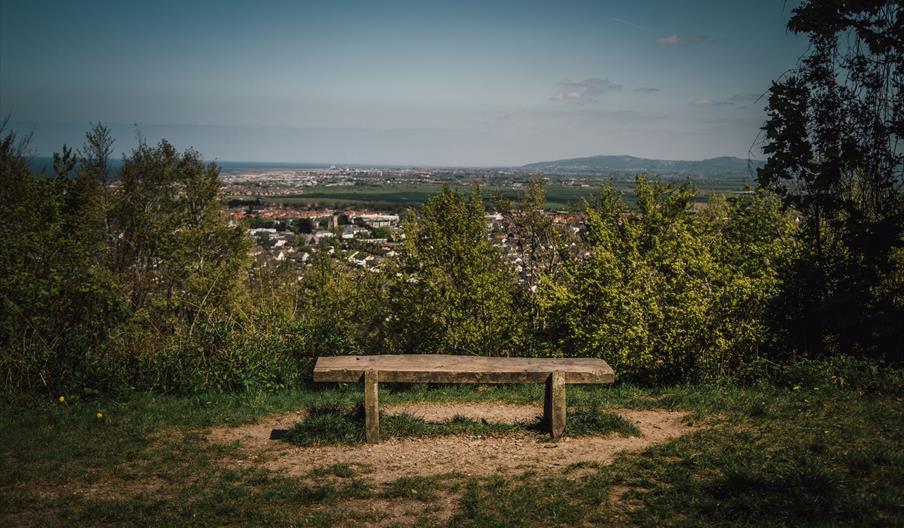 A wooden bench in the forest overlooking Abergele town