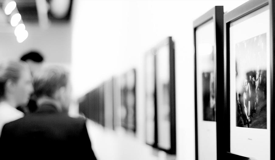 People looking at art on a wall