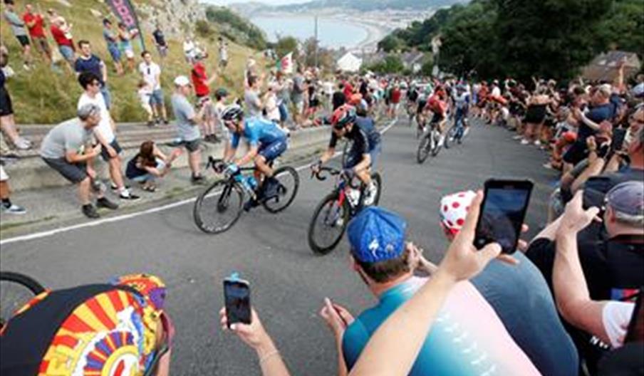 Cyclists riding up the Great Orme cheered on by the crowd.