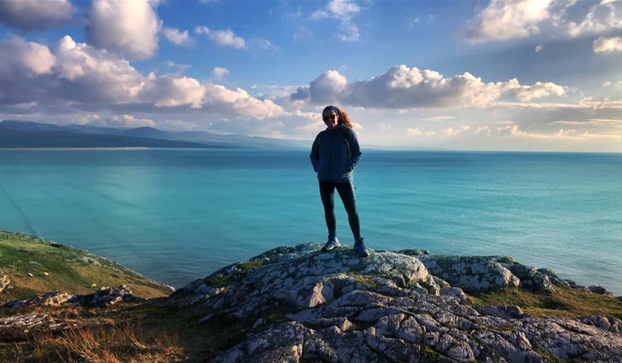 Sian Humpherson standing on mountain with sea in background
