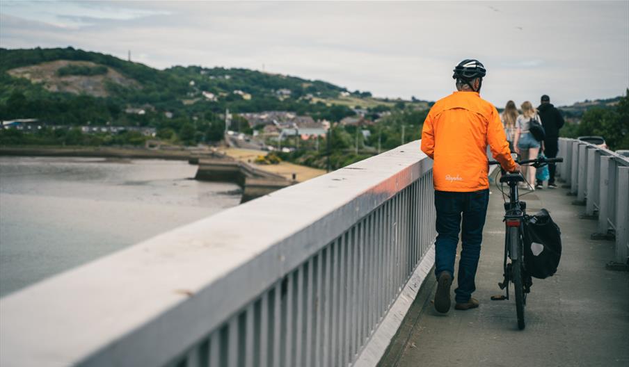Cyclist walking on Conwy Bridge