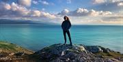 Sian Humpherson standing on mountain with sea in background